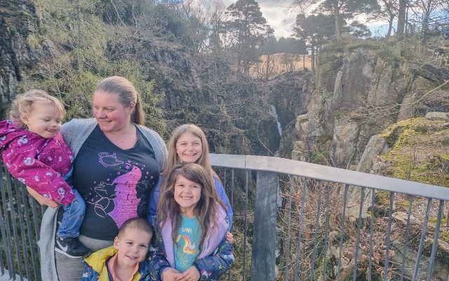 a mum and her four children on the metal viewing platform with Stanley Ghyll Force in the background 